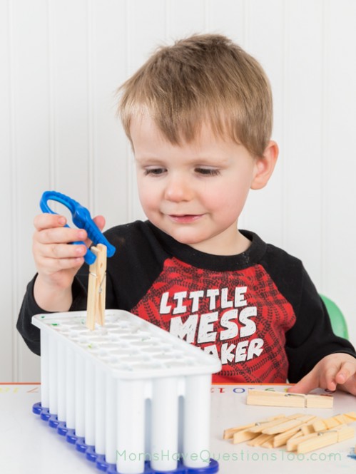 Pick up clothes pins with kid tweezer and drop into an ice cube tray - Moms Have Questions Too