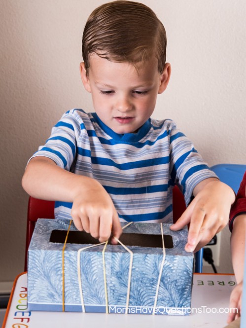 Playing the box guitar - Toddler Music Activity - Homemade Instruments - momshavequestinostoo.com