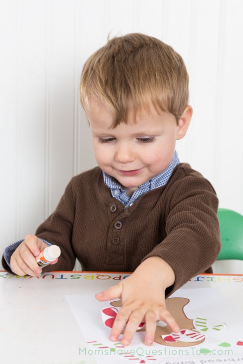 Glueing candy on a gingerbread baby - Moms Have Questions Too